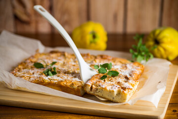 prepared curd semolina pie with quince inside and covered with powdered sugar .