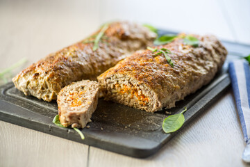 Cooked minced meatloaf with vegetable filling inside.