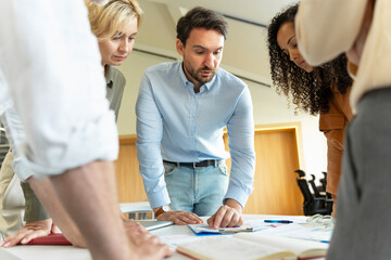 Group of confident entrepreneurs standing near desk, workplace working together in modern office