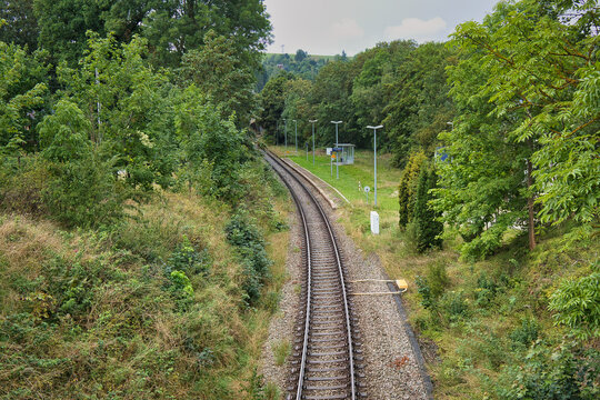 Blick von oben auf die eingleisige Bahnstrecke am Bahnhof Harra inmitten einer gr&uuml;nen H&uuml;gellandschaft nahe der Bleilochtalsperre, Th&uuml;ringen, Deutschland