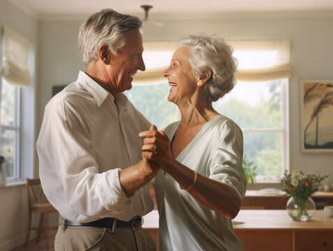 Elderly caucasian couple slow dancing in their kitchen.  Closeup with focus on their smiling faces.  