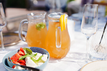 decanters with orange lemonade and vegetable salad with cheese 