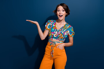Photo of young girl fashion designer holding arm demonstrate her retro style outfit surprised...