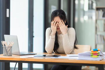 Asian businesswoman are stressed and tired from work sitting at desk in the office, feeling sick at work, stress from work.	