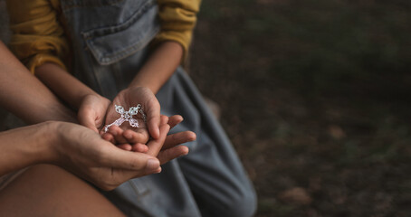 Mother and daughter putting their hands together to pray for God's blessings.