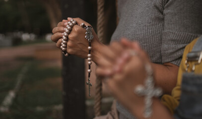Mother and daughter putting their hands together to pray for God's blessings.