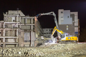 Chantier de démolition d'un bâtiment en milieu urbain pendant la nuit. Création d'un espace libre pour un projet d'aménagement