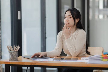 Asian businesswoman stressed and tired from work sitting in office desk, Unhappy woman feeling stressed.