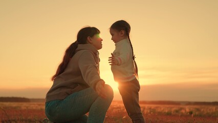 Child playing with mom happy hugs. Family in park in summer. Little child playing with parent. Happy family hugging in front of sun. Carefree childhood, joyful hugs of baby and mother in park, sunset