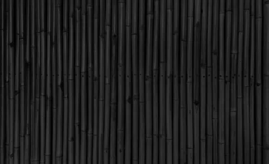 Foto auf Glas architectural dark black bamboo wall for japanese mood decoration, interior or exterior design. black bamboo plank fence texture used as background with blank space for design. © WONGSAKORN
