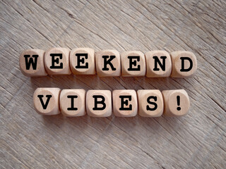 Motivational and inspirational wording. WEEKEND VIBES written on wooden blocks. With blurred styled background.