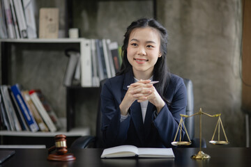 Lawyer woman with a wooden legal gavel on an office desk, justice and law concept.