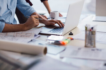 Close up of a architect sketching design and using a laptop in a modern office