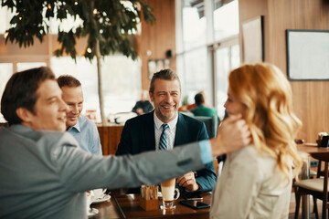 Diverse group of business friends having coffee after work in a café decorated for Christmas and the new year holidays