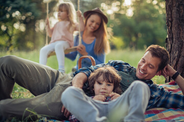 Happy young family having a picnic in the park during a sunny day