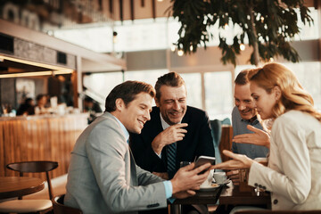 Diverse group of business friends having coffee after work in a café decorated for Christmas and the new year holidays