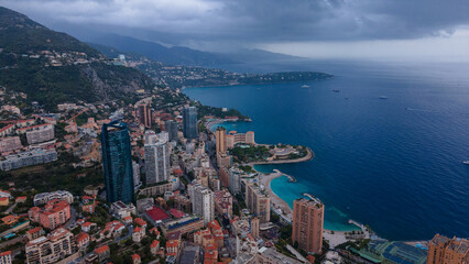 Aerial view over the city of Monaco, Monte Carlo. Photography was shoot from a drone at a higher altitude from above the city with skyscrapers and the coast in the view on a stormy weather.