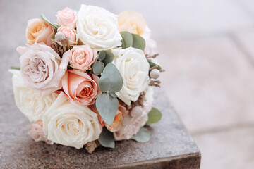 Bouquet of roses on stone surface with blurred background. Concept for wedding, anniversary, Valentines Day or Mothers Day. White, pink and peach roses symbolize love, gratitude and elegance.