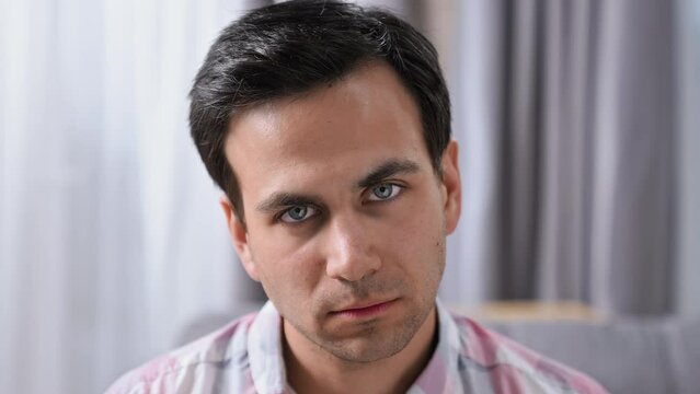 Brutal displeased 30s person look at camera. Young adult guy head shot. Annoyed angry man portrait. Rude male face close up. Bad day mood. Scary tired mad gaze. Anger grim emotion. Black hair bristle.