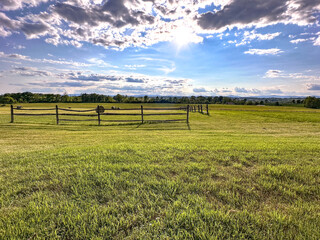 Fototapeta na wymiar Field and Sky on a farm with hay and wooden fence