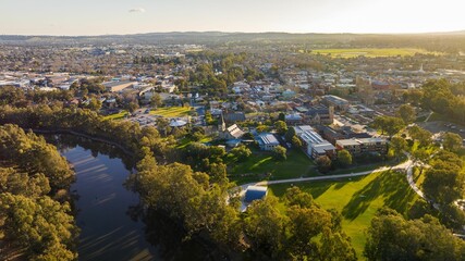 an aerial of a city and a lake with trees in the foreground, Wagga Wagga - obrazy, fototapety, plakaty