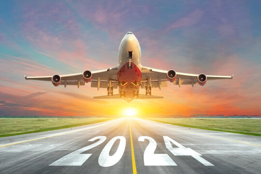 Fototapeta Inscription on the runway 2024 surface of the airport road with take off big airplane enjoy travel sunset sunrise dawn. Concept of travel in the new year, holidays.