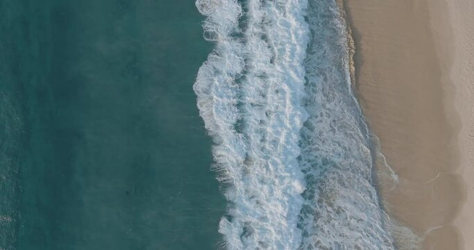 Aerial view of Bronte beach with waves rolling on the shoreline at sunset, New South Wales, Sydney, Australia.