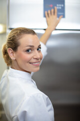 female chef pressing button to operate machinery