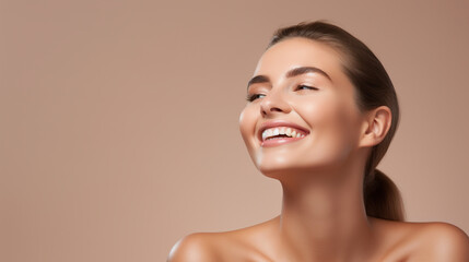 Toothy smiling young woman with shiny glowing perfect facial skin and bare shoulder looking aside beauty studio portrait on  copy space. Cosmetology, dermatology. Dental and skin treatment