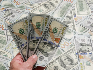 Man holding сто dollar notes, close up on hand.