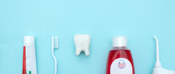 Close up of a toothbrush,  toothpaste, irrigator, mouthwash for teeth, with white molar tooth model...