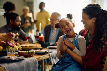 Cheerful black girl have fun during family meal at dining table on Thanksgiving. - obrazy, fototapety, plakaty