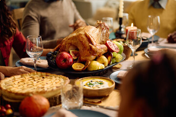 Thanksgiving turkey with family gathered at dining table.