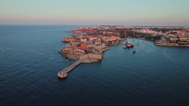 Aerial view of Saint Elmo breakwater and Fort Saint Elmo at the point of La Valletta downtown at sunset in Malta.