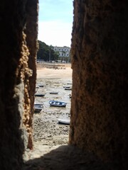 Vistas desde el Castillo de Santa Catalina. Marea baja , vistas de pequeños barcos pesqueros y de la playa de la Caleta. Cádiz. Andalucía. España.