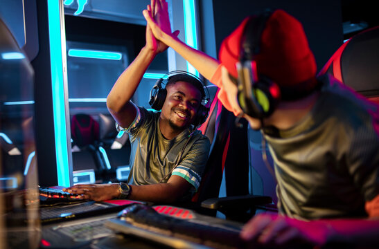 Pair of professional male gamers high fiving each other during a esport tournament