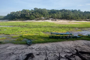 Fototapeten Boat stranded on dry river in extreme drought in the Amazon Rainforest, the largest tropical forest in the world. Concept of climate change, global warming, environment, ecology, disaster, weather. © Imago Photo