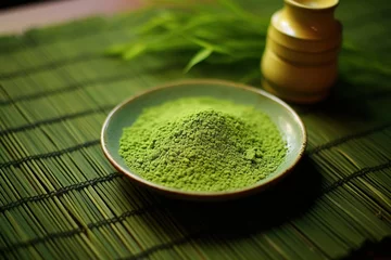 Schilderijen op glas A vibrant green matcha tea powder sprinkled on a bamboo mat © Dan