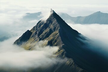 Aerial view of a lone mountain peak breaking through morning mist