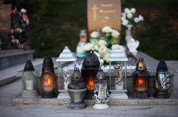 Close up of Votive candles lantern on the grave in Slovak Catholic cemetery during day. Autumn scene. All Hallows eve. Memorial to the deceased. Solemnity of All Saints. 1st November, All Saints' Day