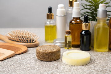 Fototapeta na wymiar Natural eco-friendly cosmetics for hair care - solid shampoo, hair oils, wooden combs.