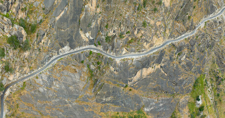 aerial view of a road on the edge of mountains carved out of rocks