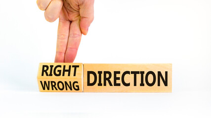 Right or wrong direction symbol. Concept words Right direction Wrong direction on wooden blocks. Beautiful white background. Businessman hand. Business right or wrong direction concept. Copy space.