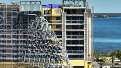 Aerial view of ruined by hurricane Ian construction scaffolding on high apartment building site in Port Charlotte, USA