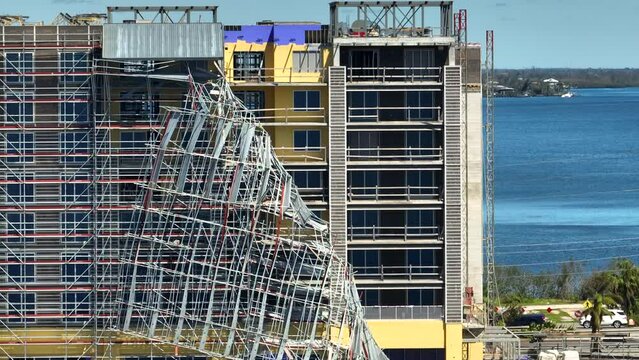 Aerial view of ruined by hurricane Ian construction scaffolding on high apartment building site in Port Charlotte, USA