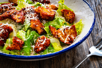 Vegetarian style caesar salad on wooden background.