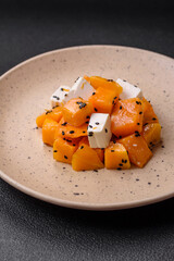 Delicious juicy salad of diced grilled pumpkin with feta cheese, spices and sesame seeds