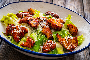 Vegetarian style caesar salad on wooden background.