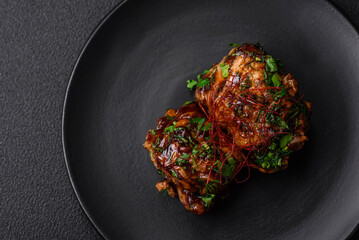 Delicious juicy fried chicken in teriyaki sauce with salt, spices, herbs and sesame seeds