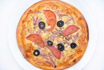 Meat round pizza with olives on a white plate. Italian flatbread.